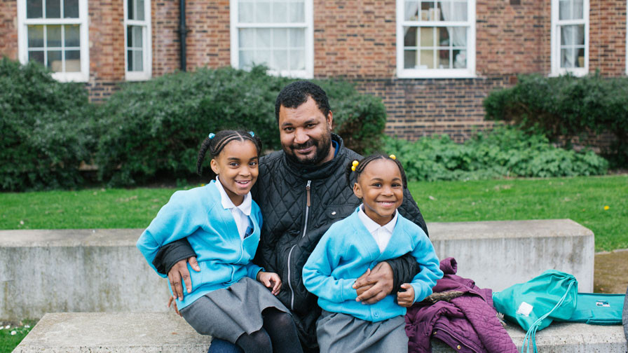 father with two daughters in blue cardigans