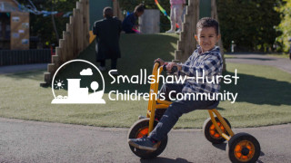 small boy on a tricycle looking at the camera